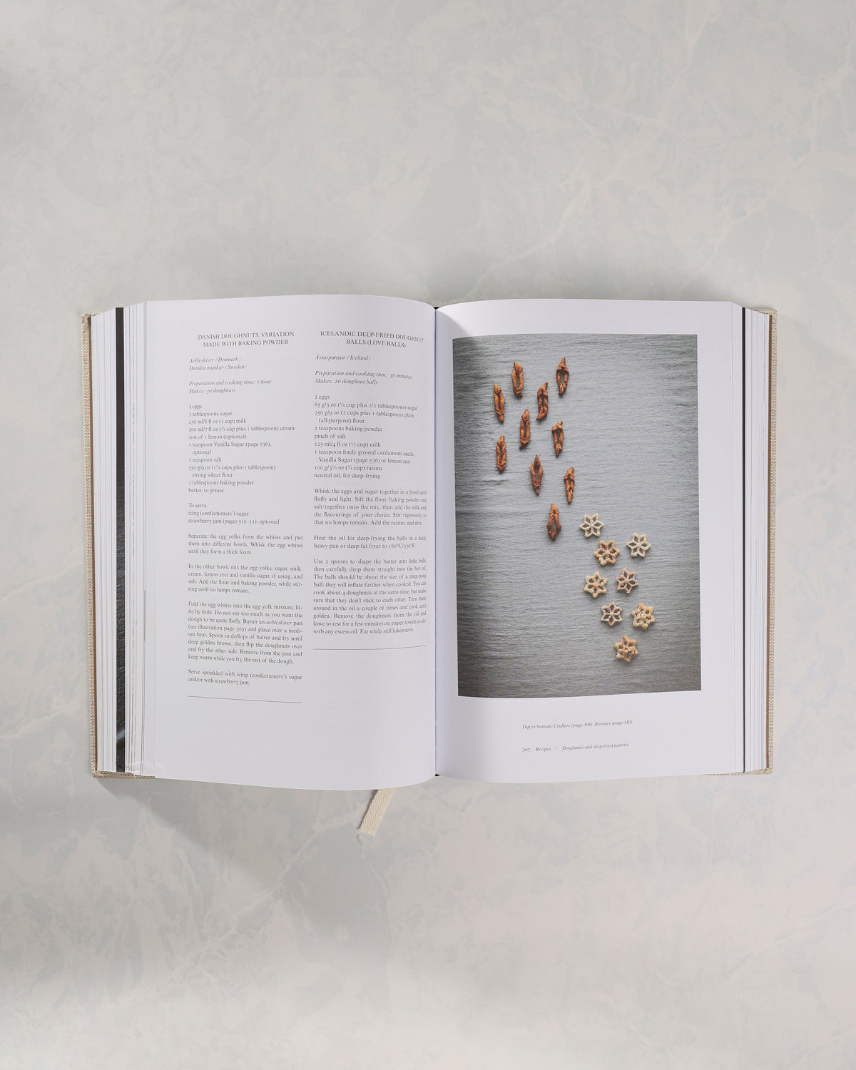 Open recipe spread from The Nordic Baking Book with recipes on the left and a photograph of small baked goods arranged on the right.