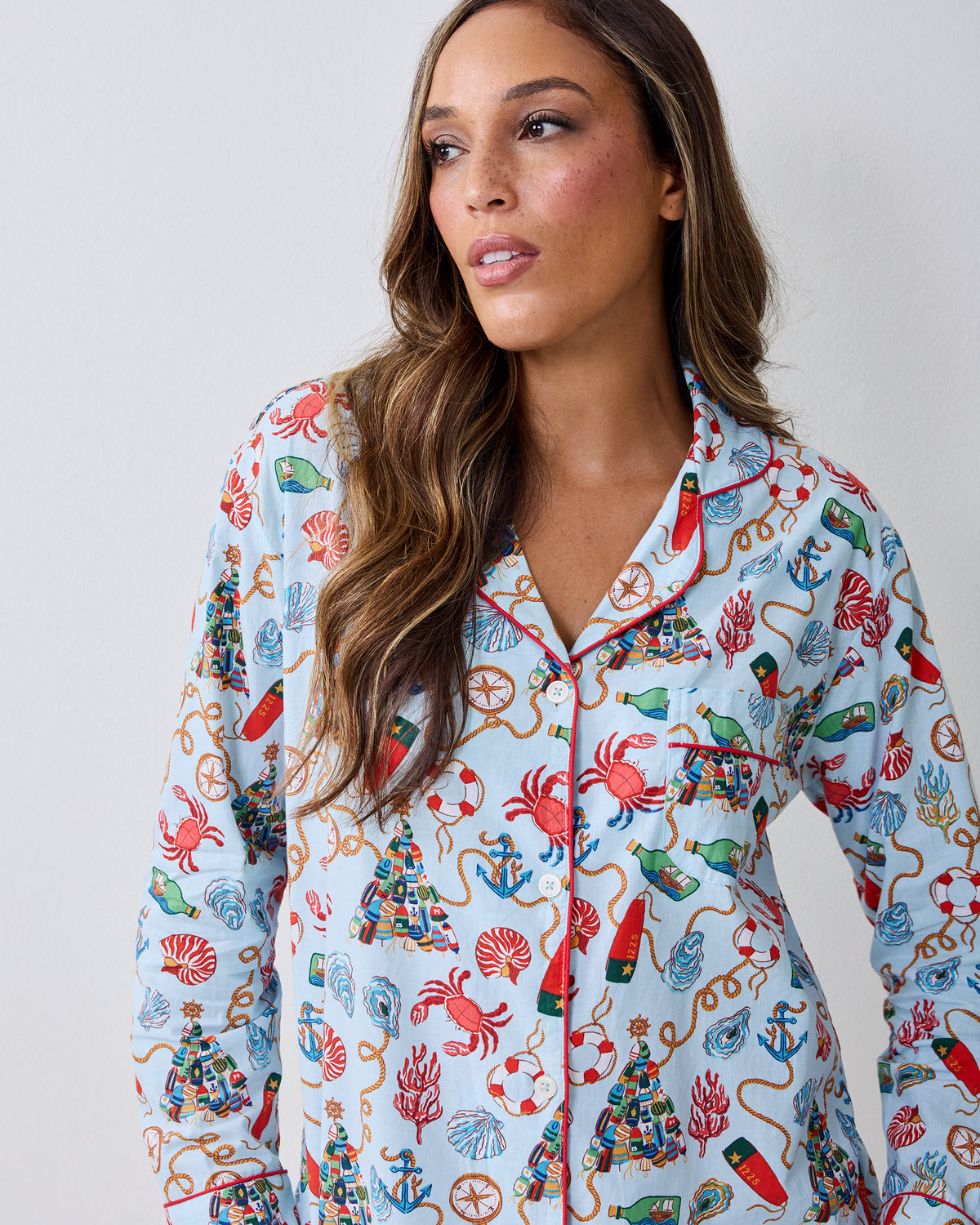 Close-up front view of a light blue button-front pajama top with a nautical Christmas print and chest pocket.