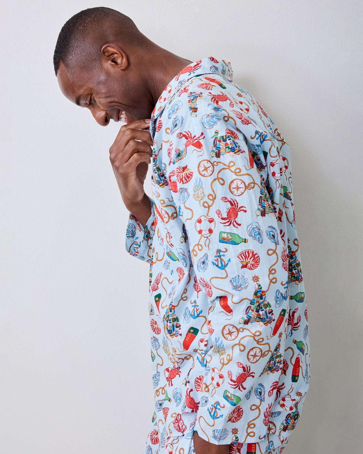 Side view of a person wearing the Holidays Ahoy long pajama set with a button-front top and nautical print.
