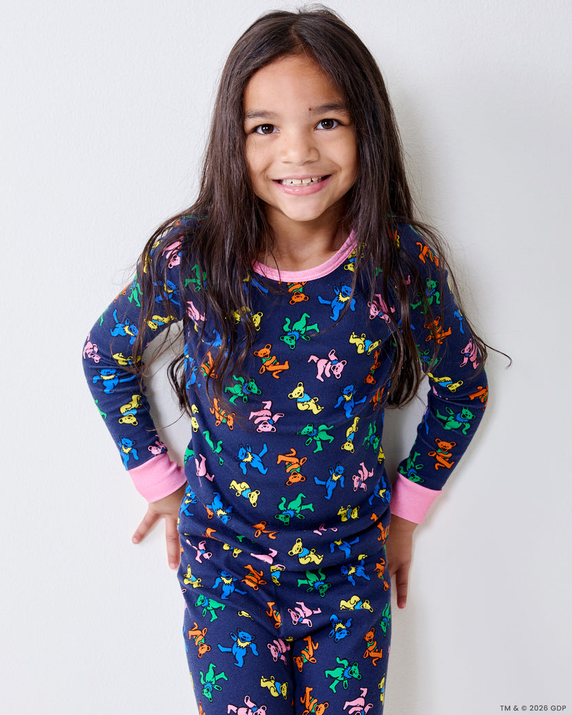 Child wearing the Dancing Bears kids snug fit long pajama set in Backstage Blue, standing against a light wall.
