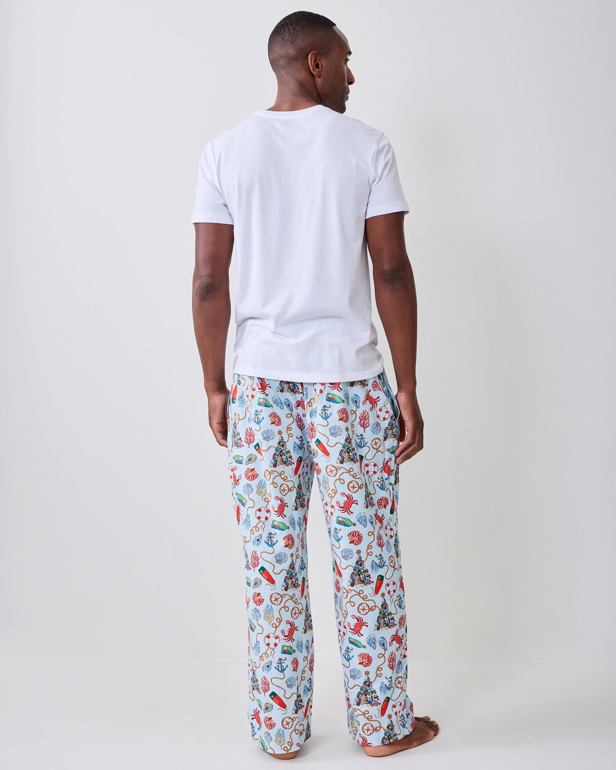 Back view of the men's long pajama pants with a light blue nautical holiday print.