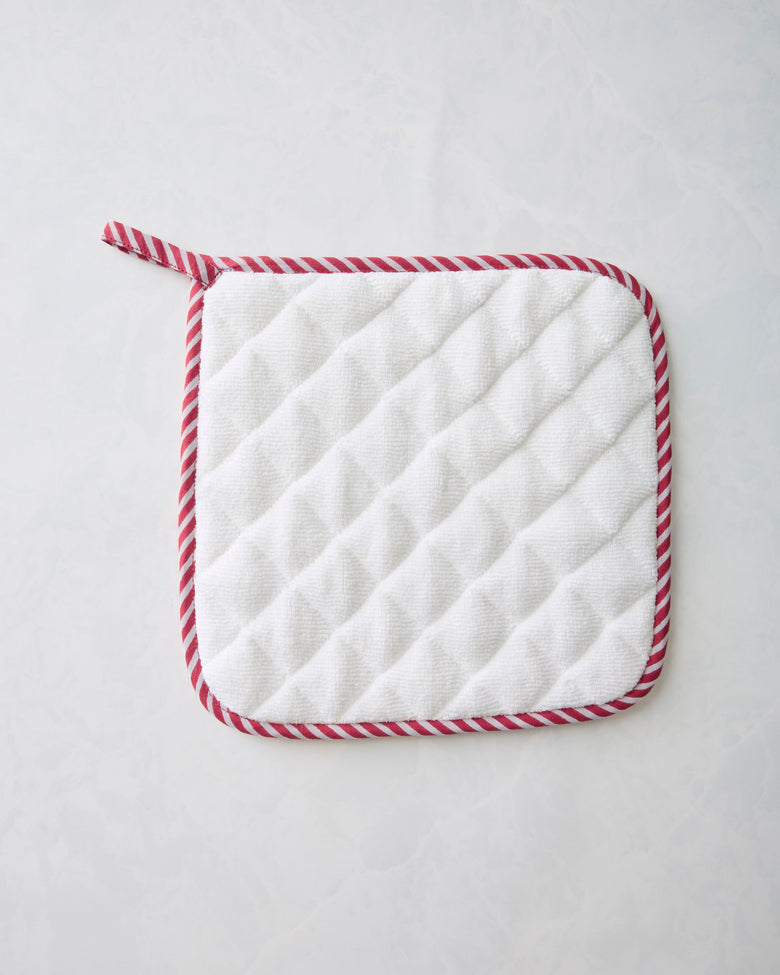 Back of the pot holder showing a white quilted surface with red-and-white striped edging.