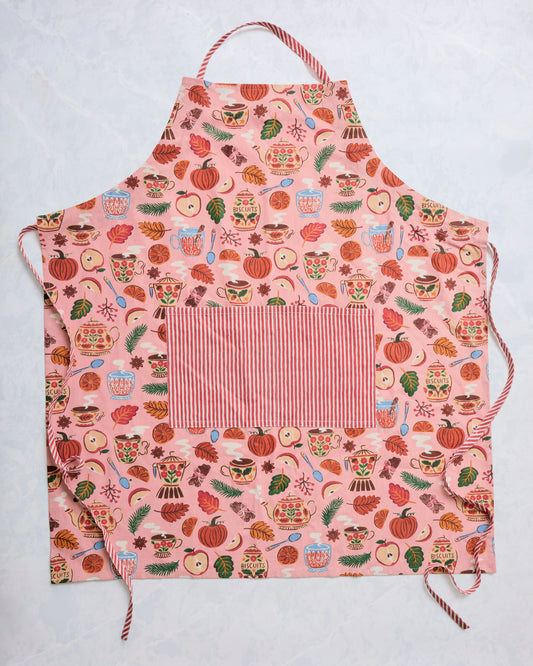 Rose-pink autumn print apron with striped neck strap, waist ties, and a large striped front pocket.