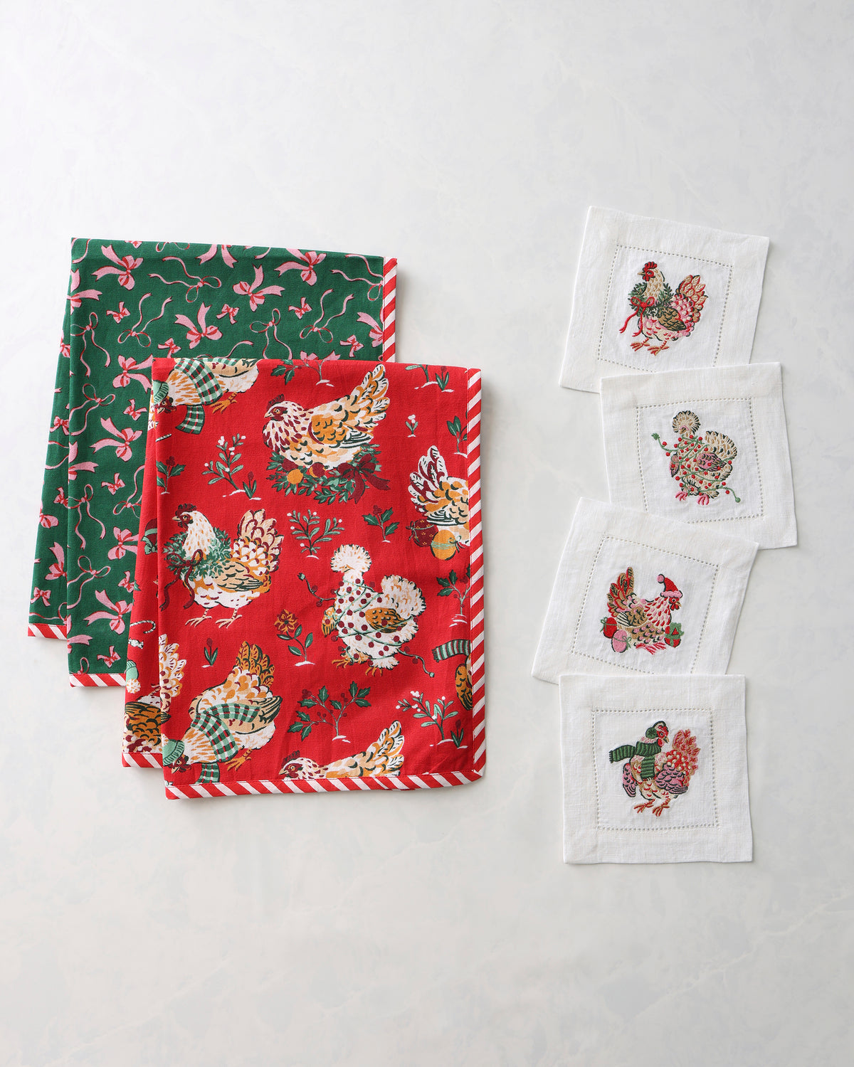 Holiday Hens kitchen bundle with two printed tea towels and four white embroidered cocktail napkins.