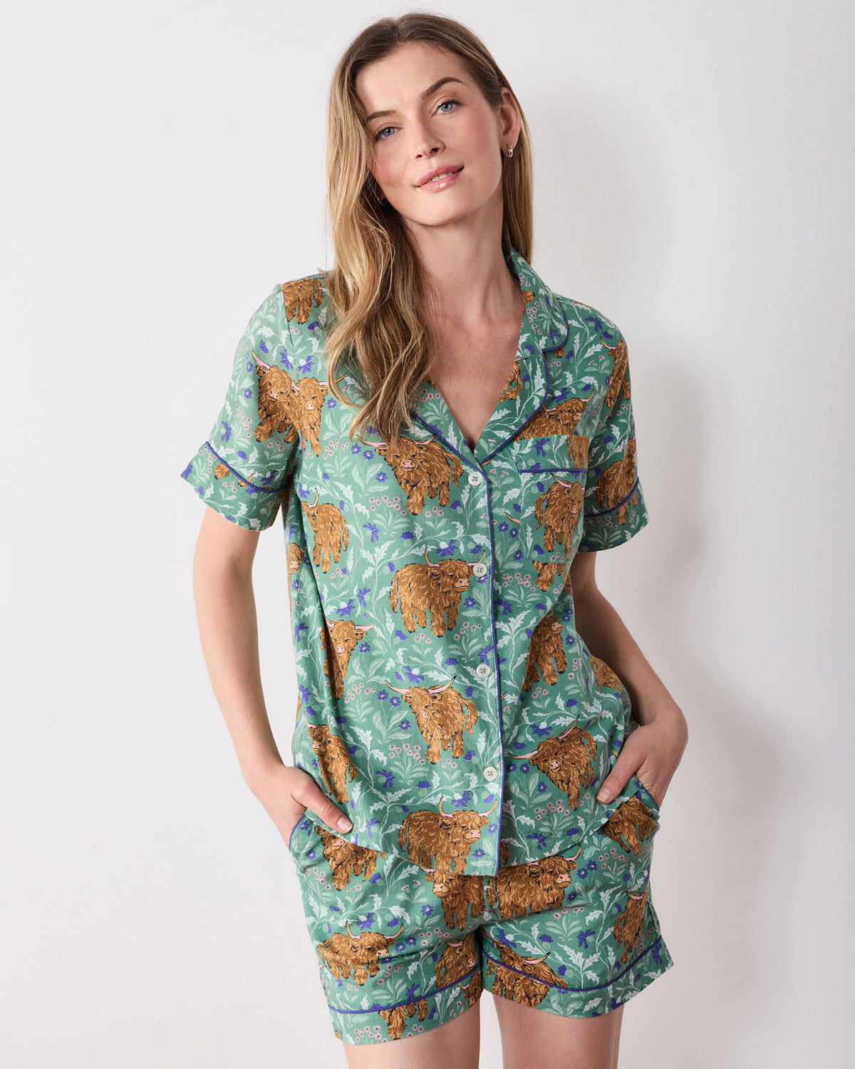 Front view of the Soft Thistle Highland Cows short pajama set with button-down top, pocket, and matching shorts.