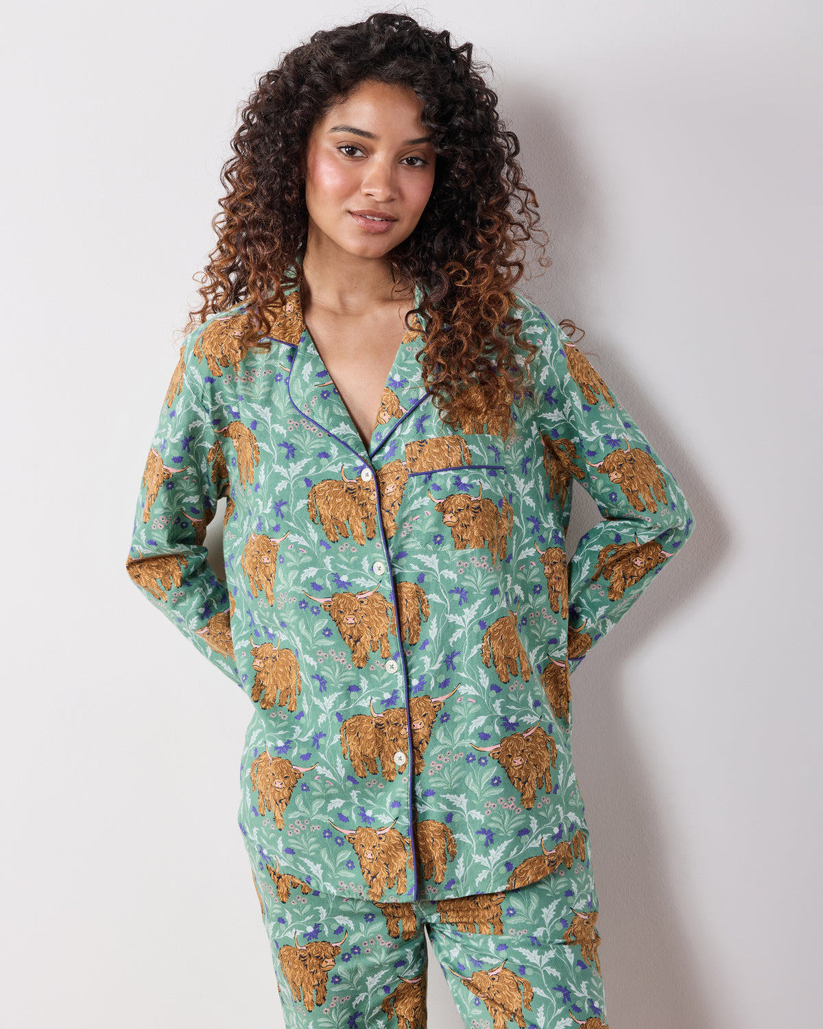 Front view of the green Highland Cows tall long pajama set with a button-down top, chest pocket, and matching pants.