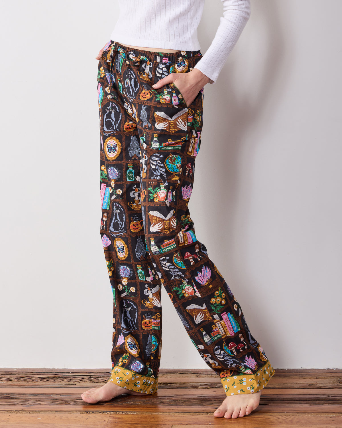 Side-front view of the Enchanted Study pajama pants, showing the drawstring waist, side pocket, wide legs, and contrasting cuffs.