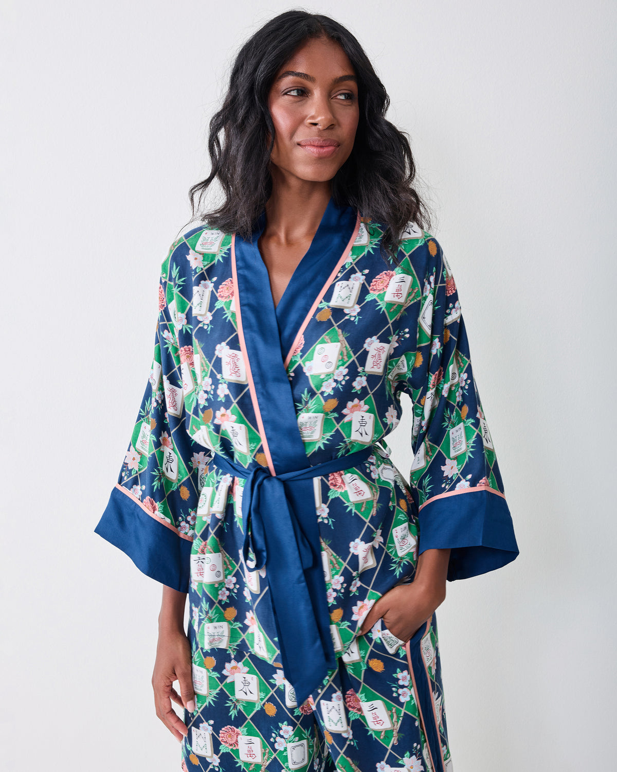 Front view of the Mahj Garden Eco Satin Wrap Set in Wintergreen, featuring a wrap top with blue contrast trim, waist ties, wide sleeves, and matching wide-leg pants.