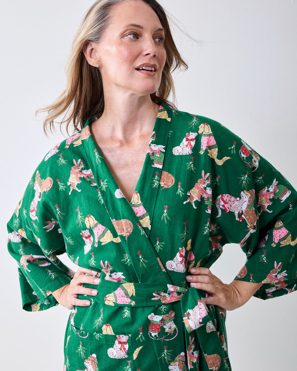 Person wearing the green Mistletoe Kiss long robe with a matching belt, long sleeves, and festive animal print.