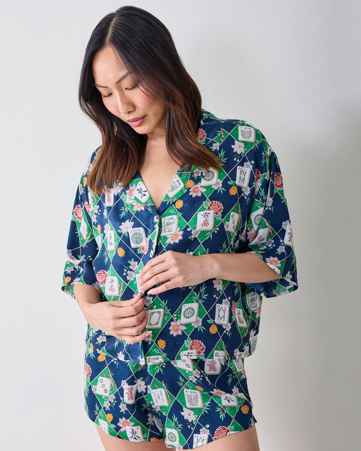 Three-quarter front view of the Mahj Garden Eco Satin Sweet Dreams Set in Wintergreen, showing the button-front top, short sleeves, matching shorts, and floral mahjong-tile print.