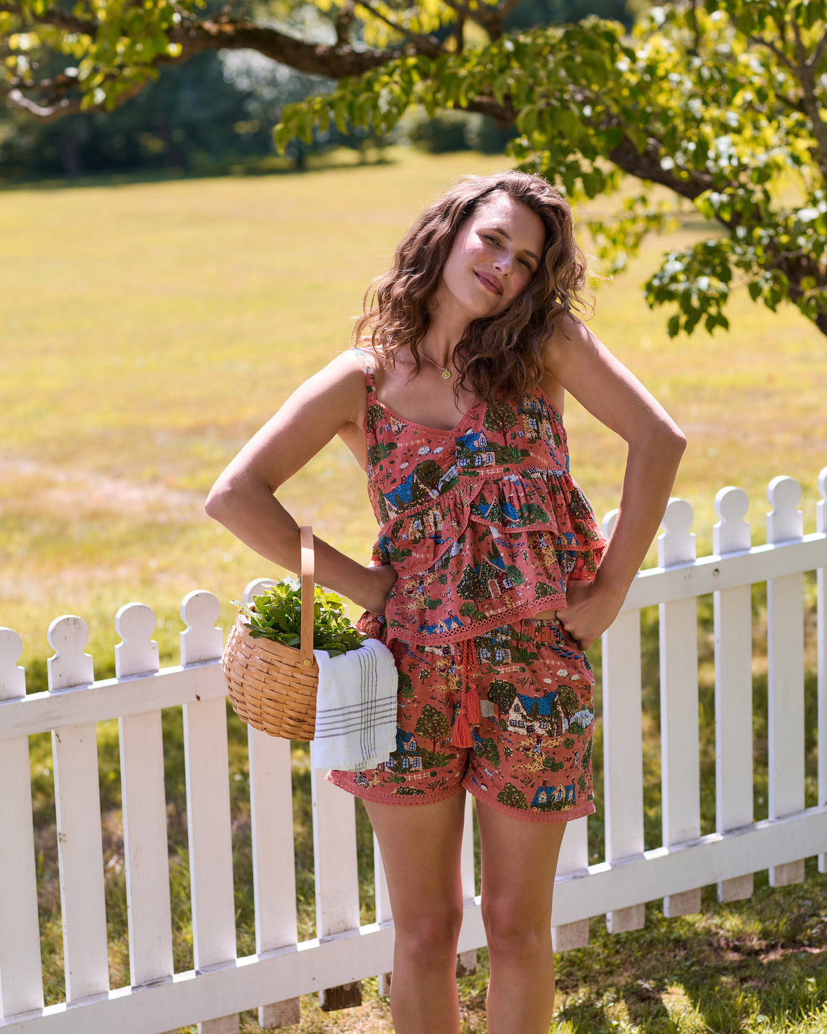 Person modeling the dusty rose English Countryside Lindsey pajama set while holding a basket of greenery.