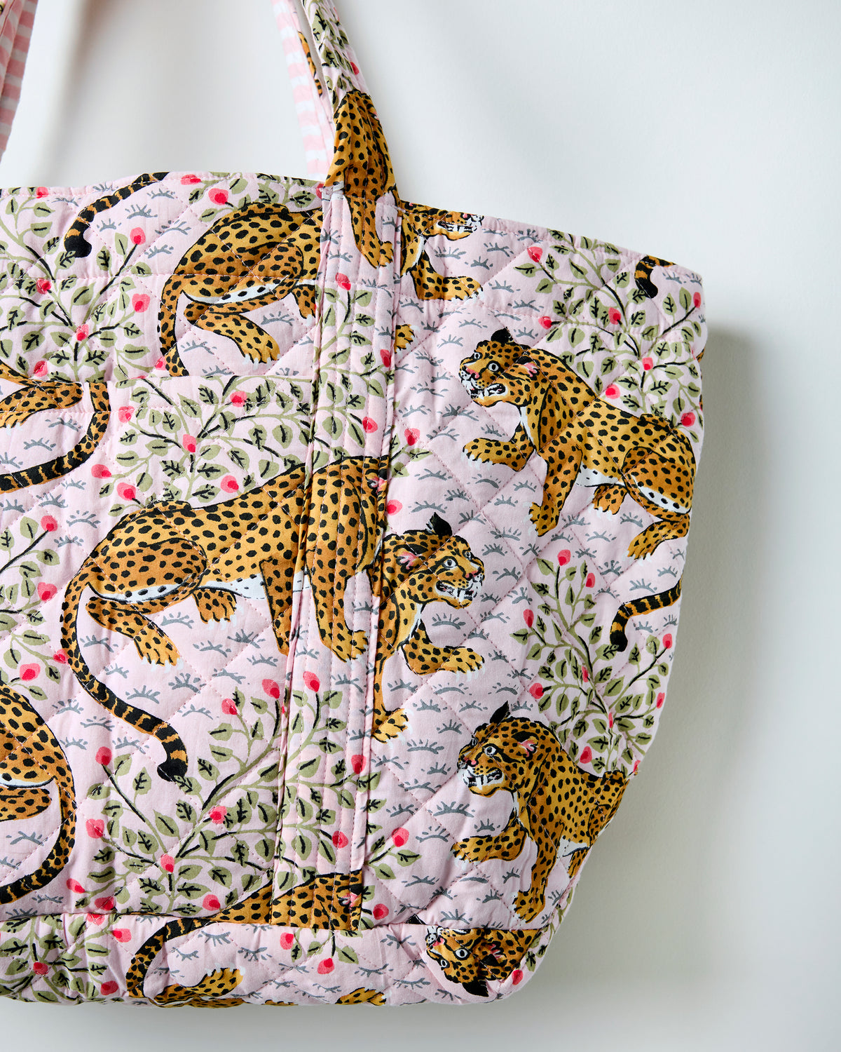 Close-up of the Bagheera weekend bag showing quilted stitching and spotted big-cat, leaf, and flower print.
