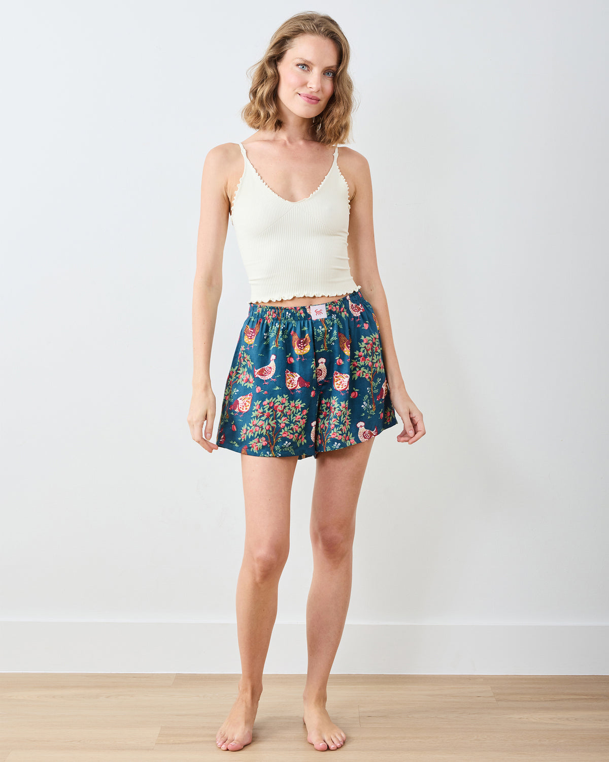 Full-length view of a model wearing navy Hen House boyfriend boxers with a chicken-and-floral print.