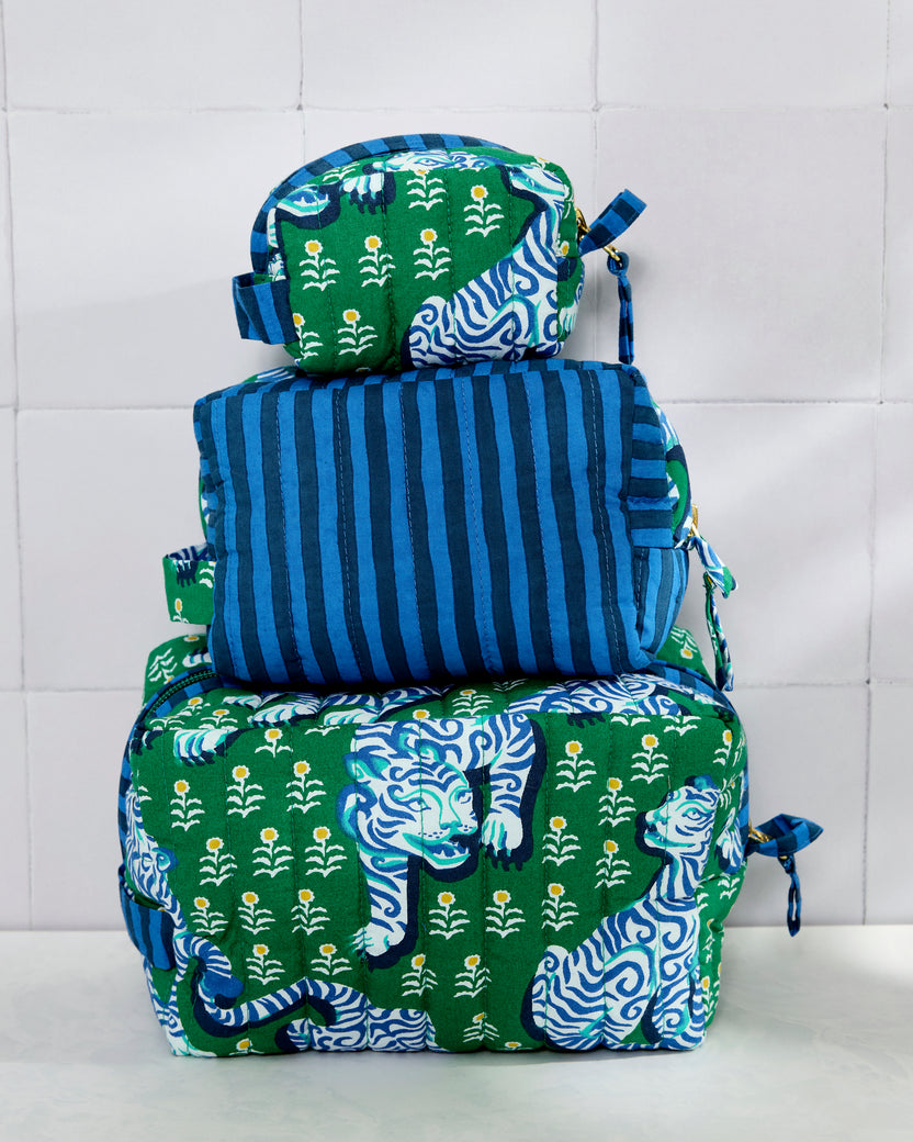 Three quilted pouches stacked vertically, showing a green tiger print on the large and small pouches and blue stripes on the medium pouch.