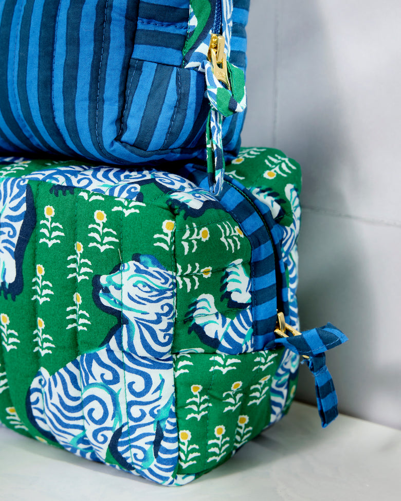Close-up of the striped medium pouch beside the tiger-print large pouch, showing quilted stitching, zippers, and fabric ties.