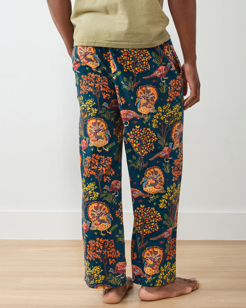 Close back view of the navy Turkey Trot long pajama pants showing the waistband, pockets, and colorful turkey and autumn foliage print.