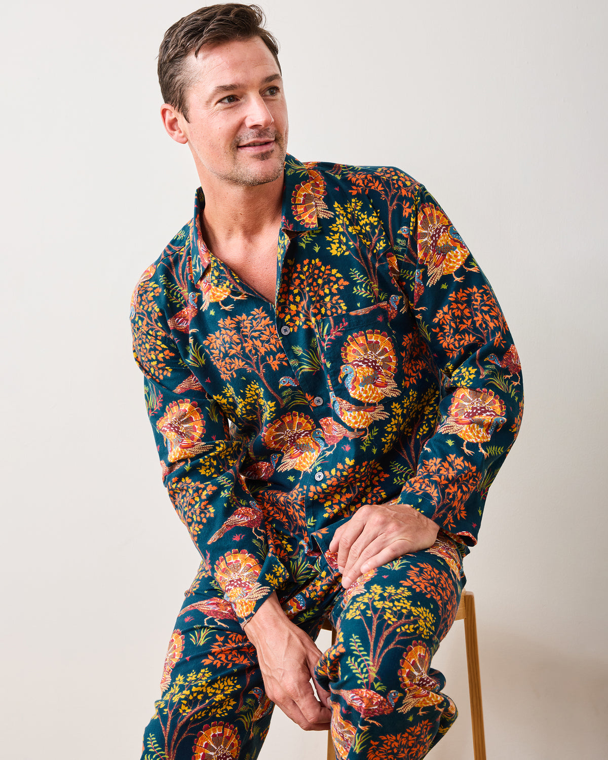 Three-quarter view of the Turkey Trot navy long pajama set with a button-front shirt and matching turkey-and-floral print pants.