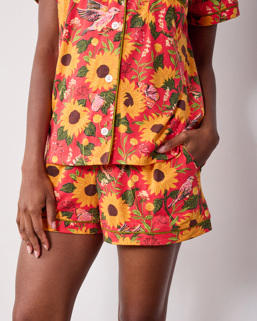Close-up of the orange Autumn Sunflowers short pajama set showing the shirt buttons and matching piped shorts.