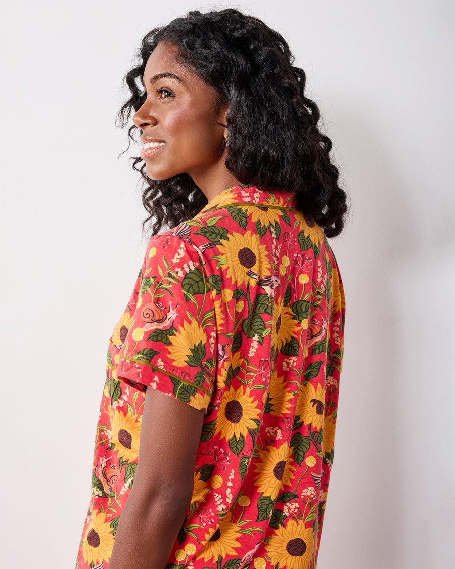 Close side and back view of the orange floral pajama top, showing its collared neckline, short sleeve, and print.