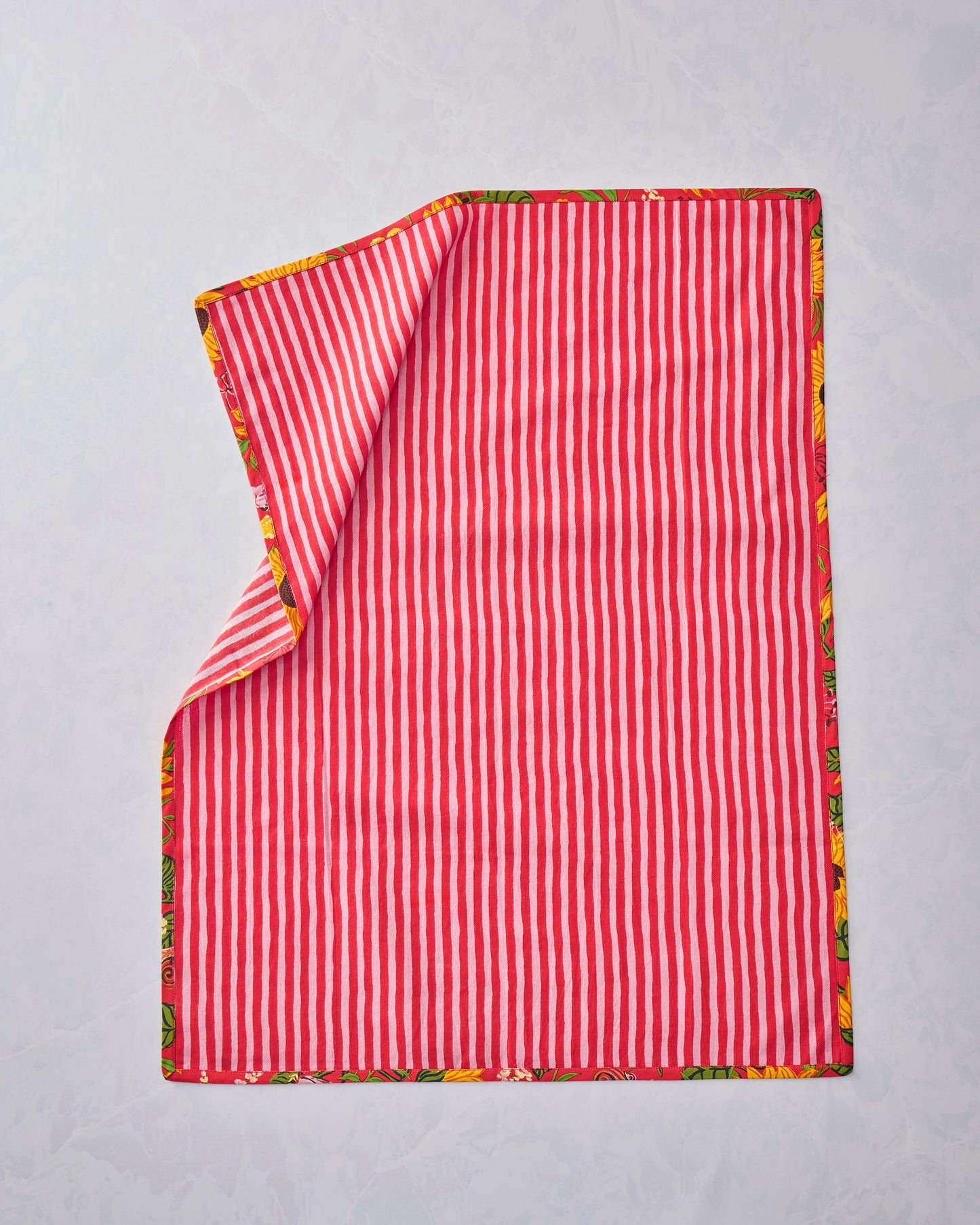 Two tea towels shown from the striped side, with one corner folded back to reveal the floral border.