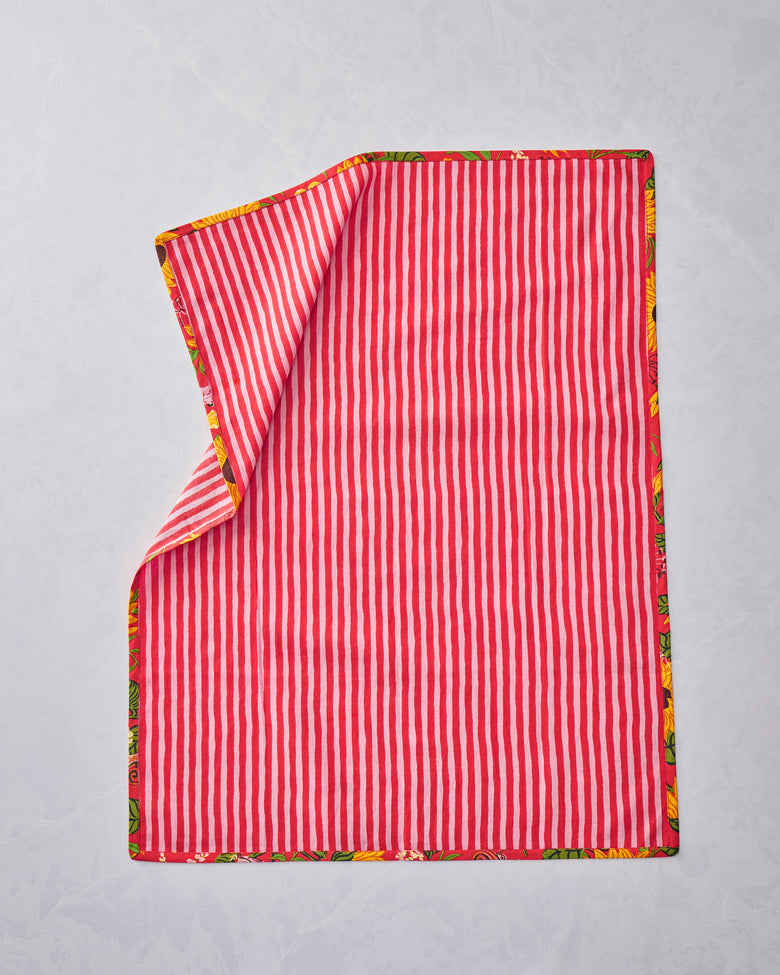 Two tea towels shown from the striped side, with one corner folded back to reveal the floral border.