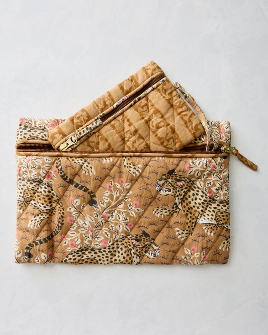 Two quilted zippered pouches in brown and tan prints, one open and layered above the other.