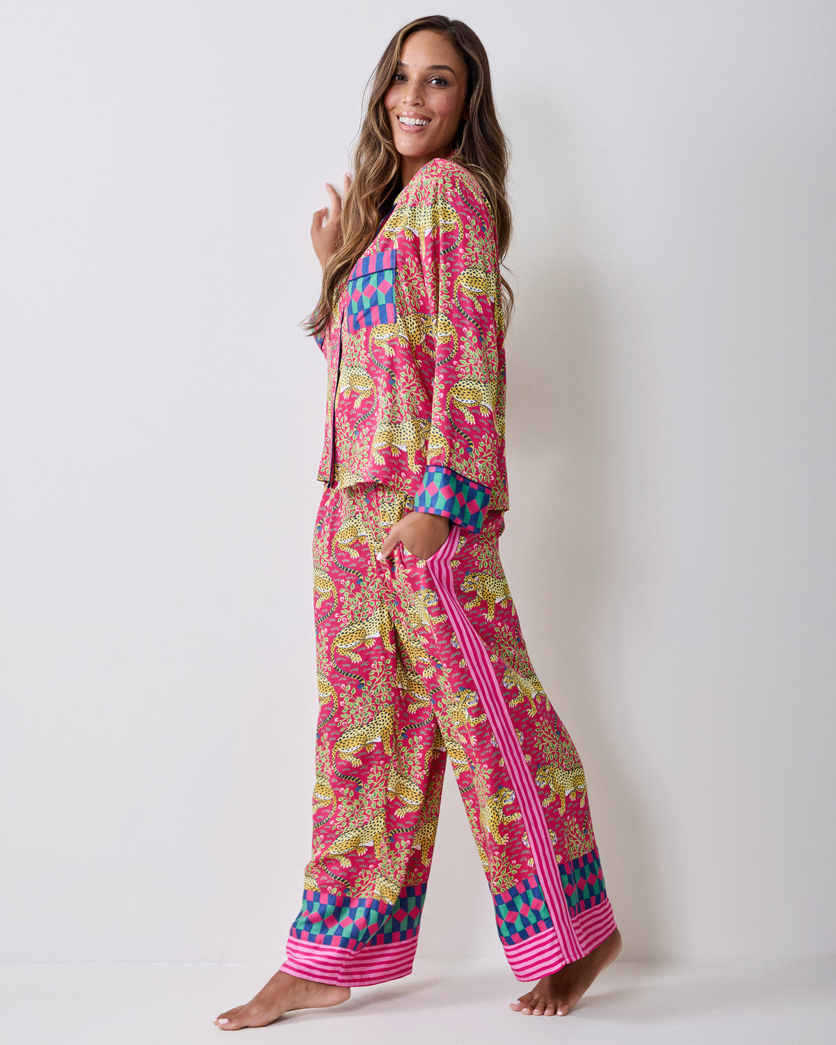 Side view of the hot pink Bagheera Tall pajama set with leopard-and-vine print, wide-leg pants, striped trim, and contrasting geometric cuffs.