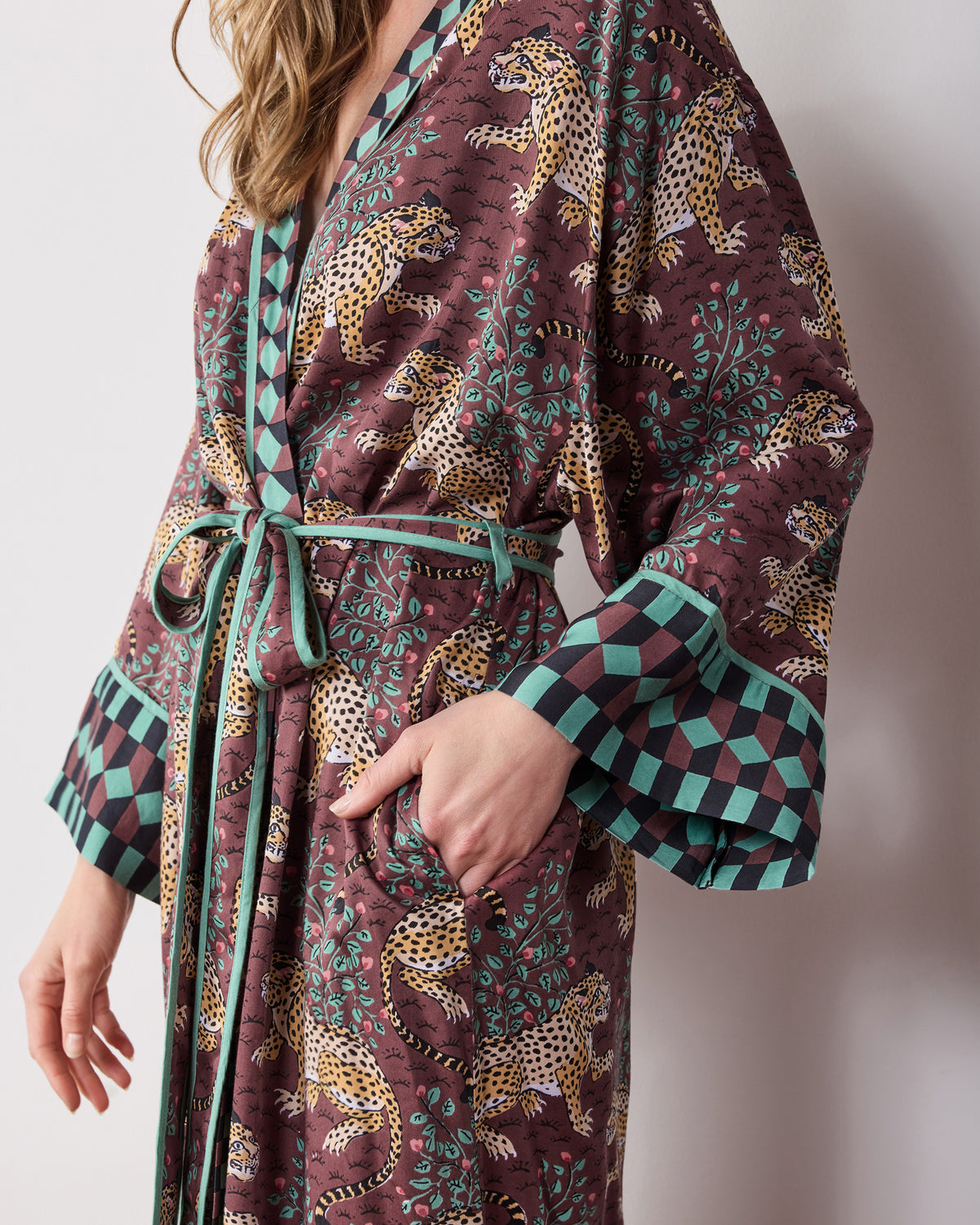 Close-up of the Bagheera Raisin Eco Satin robe showing the tie belt, front pocket, patterned fabric, and contrasting geometric cuff.