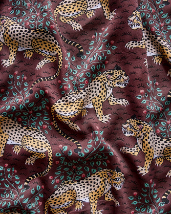 Dark reddish-brown pattern with illustrated spotted leopards and leafy branches.