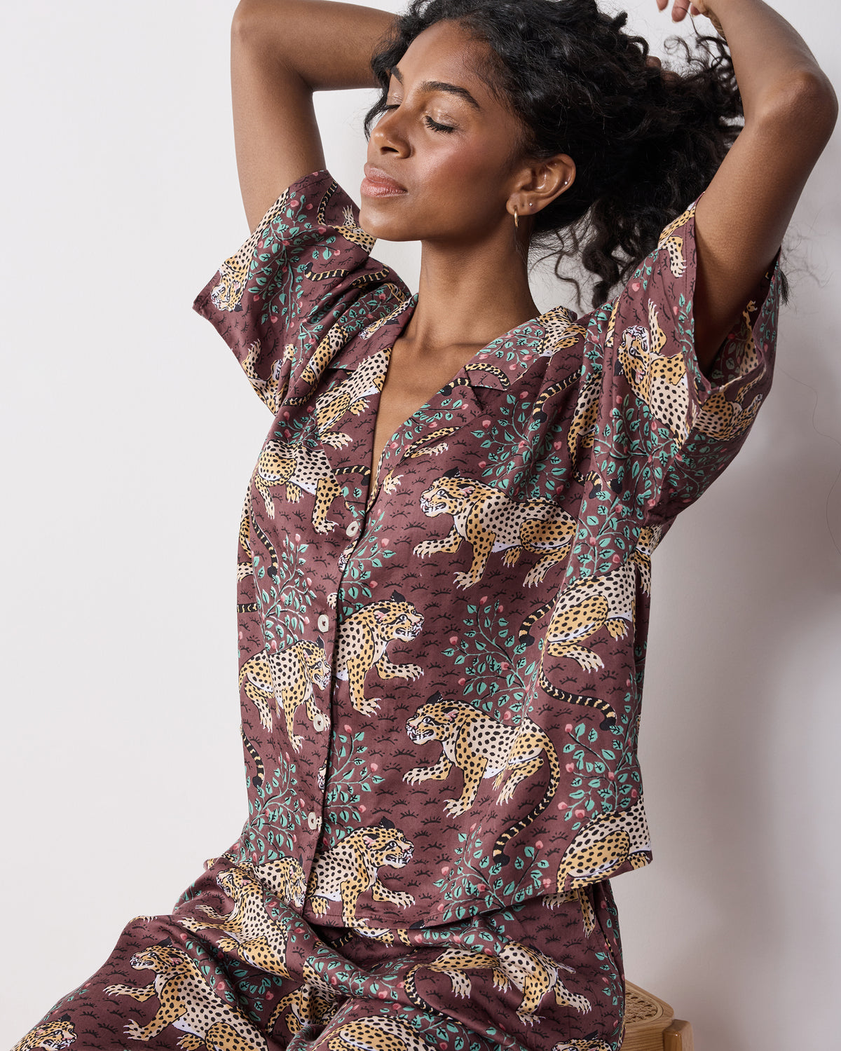 Front three-quarter view of a person wearing the cropped top and wide-leg pants from the Raisin leopard-print pajama set.