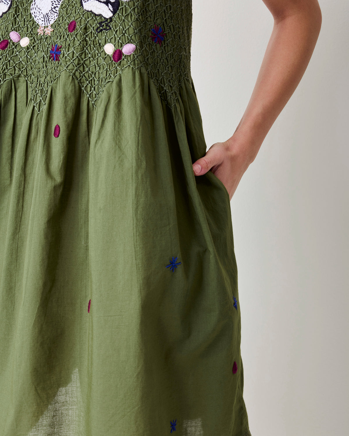 Close view of the olive nightie’s gathered skirt with small blue and magenta motifs and a side pocket.