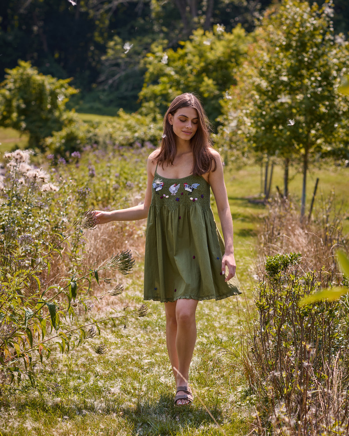 Full-length view of the Chickens & Roosters Tulsi nightie with chicken print in a garden.