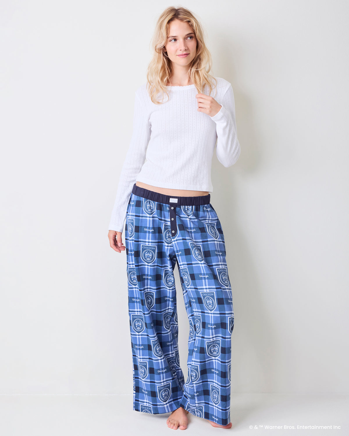 Person wearing blue plaid Chilton pajama pants with a dark waistband and button fly, shown from the front.