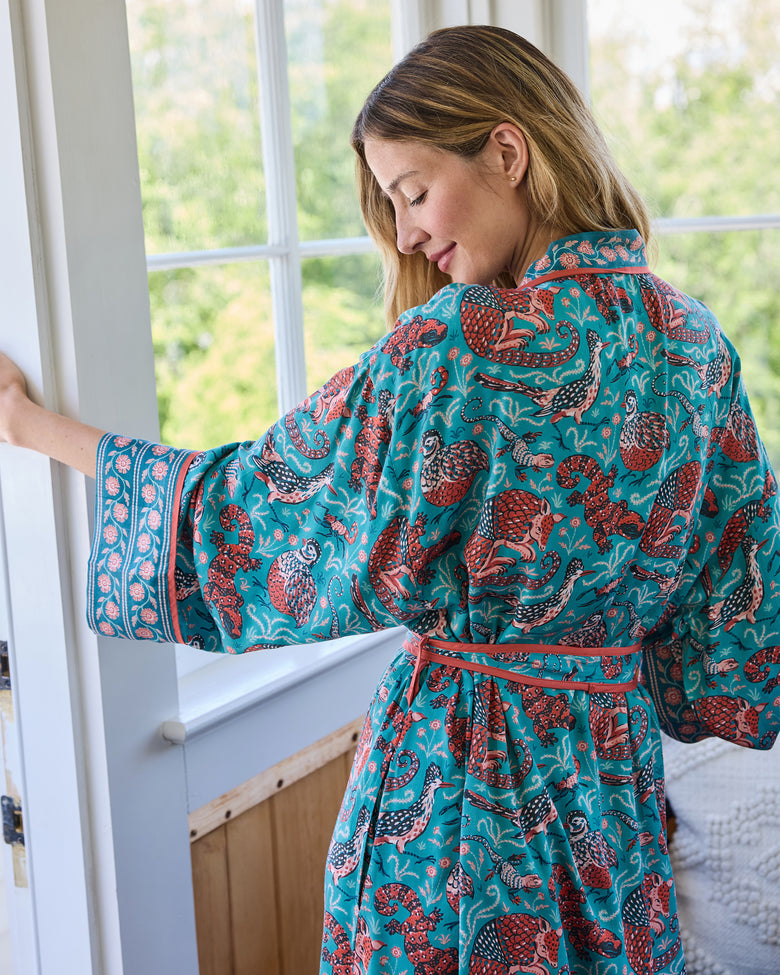 Back view of the teal Southwestern Critters satin robe showing the wide sleeves, patterned cuffs, tie belt, and all-over print.