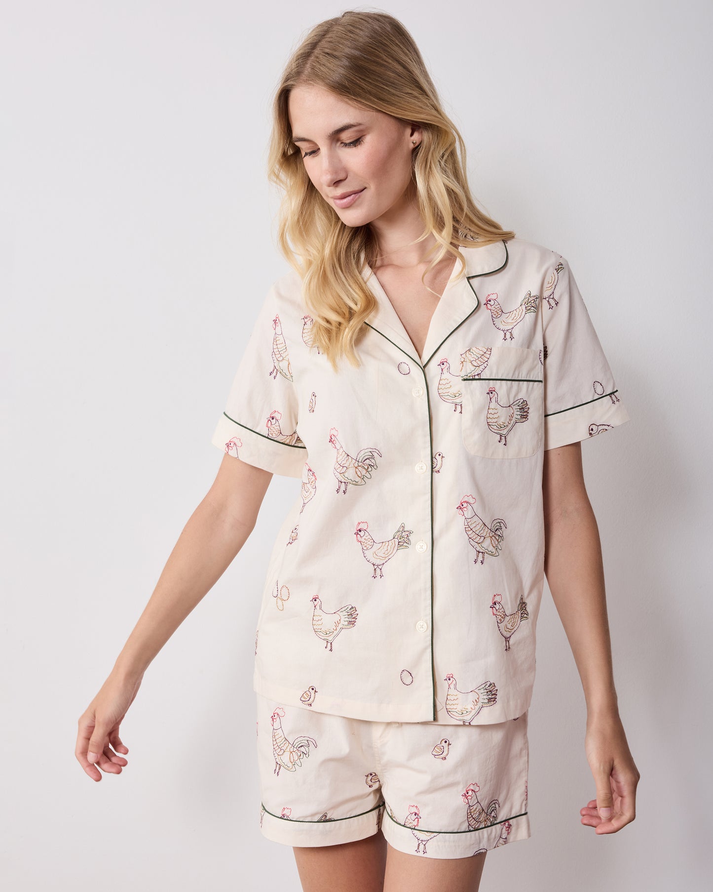 Front view of the short pajama set with a short-sleeve button-front top, chest pocket, and matching shorts with embroidered hens.