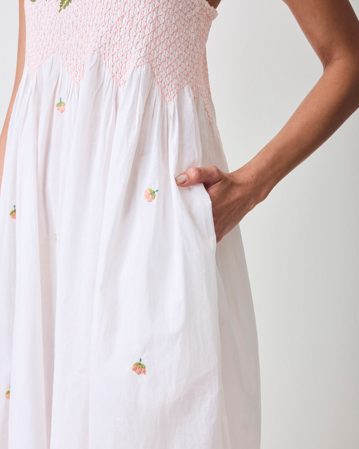 Close-up of the nightgown’s smocked bodice, small embroidered pumpkin details, and side pocket.