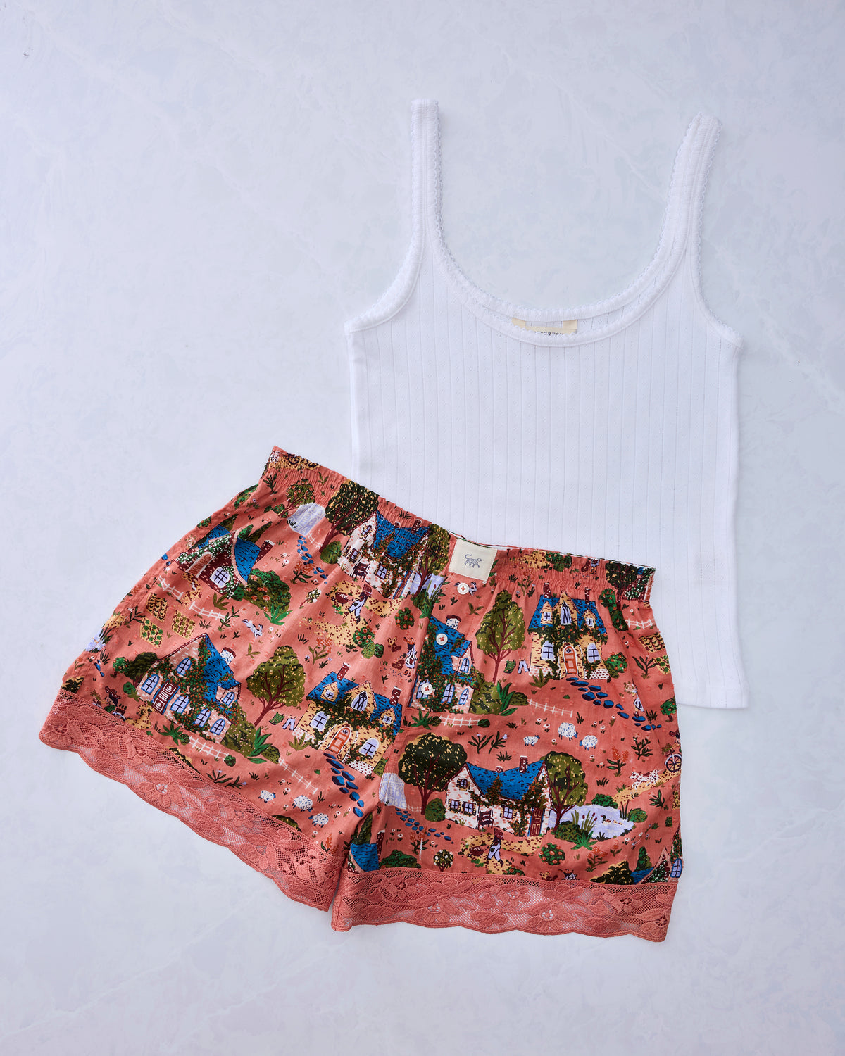 Dusty rose pajama bundle with a white pointelle tank top and storybook-cottage print boxer shorts with lace trim.