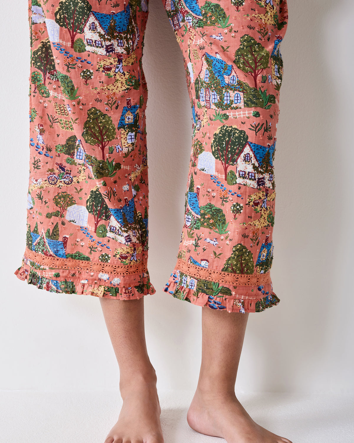 Close-up of the Colette pajama set's cropped pant legs with ruffled hems and lace trim.