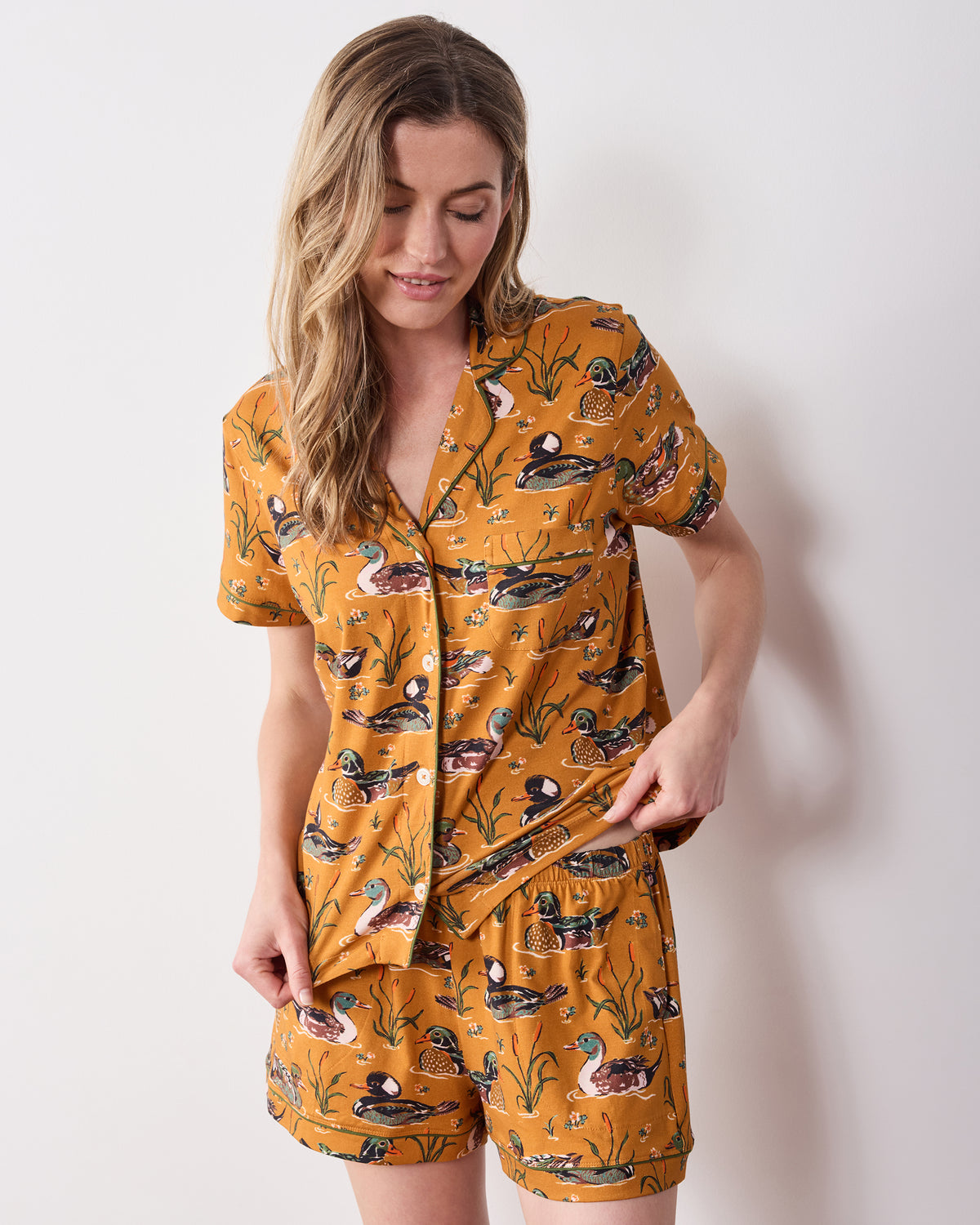 Front view of the mustard Duck Pond short pajama set with a duck print, short-sleeve button-down top, and matching shorts.