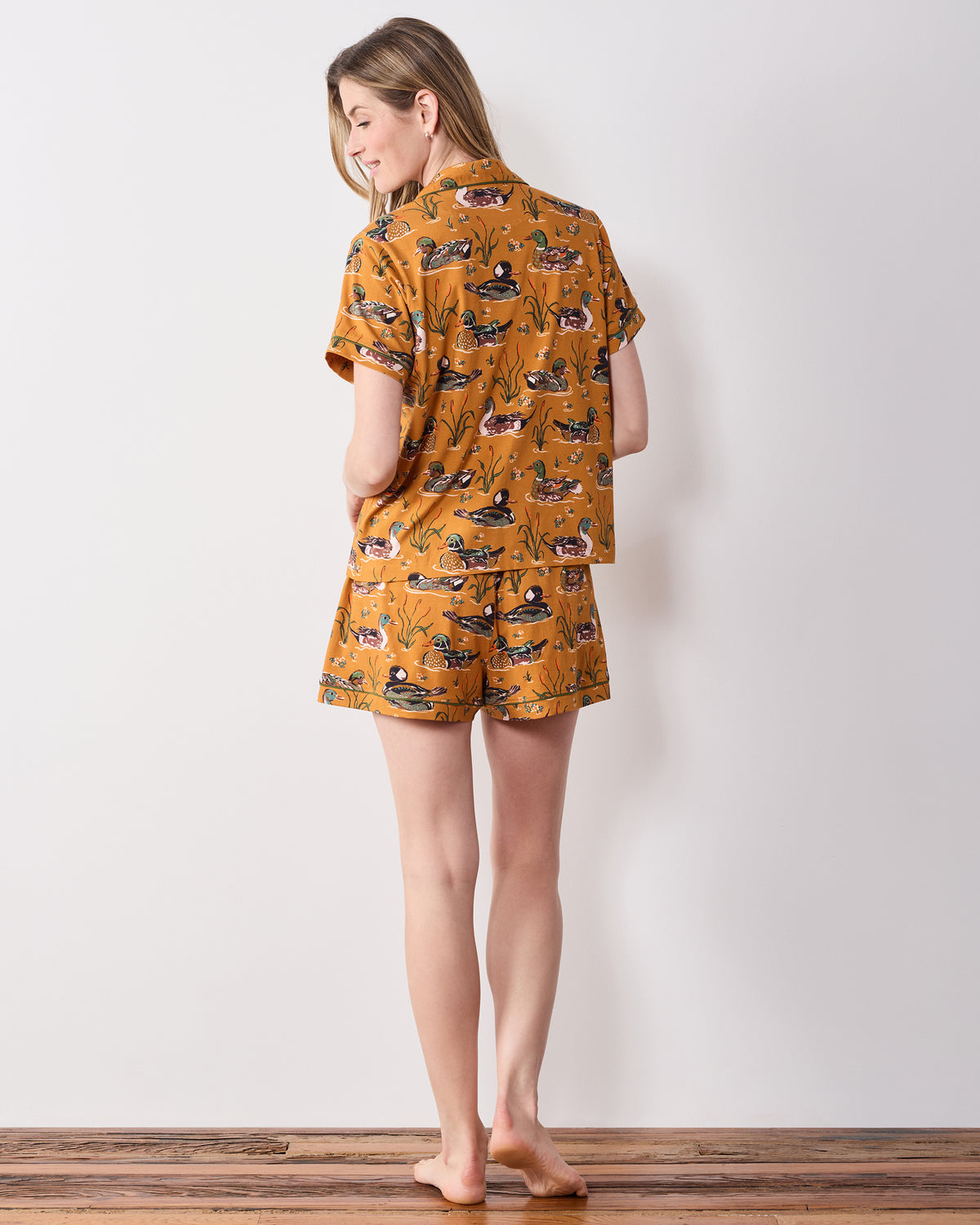 Back view of the mustard Duck Pond short pajama set showing the printed short-sleeve top and matching shorts.