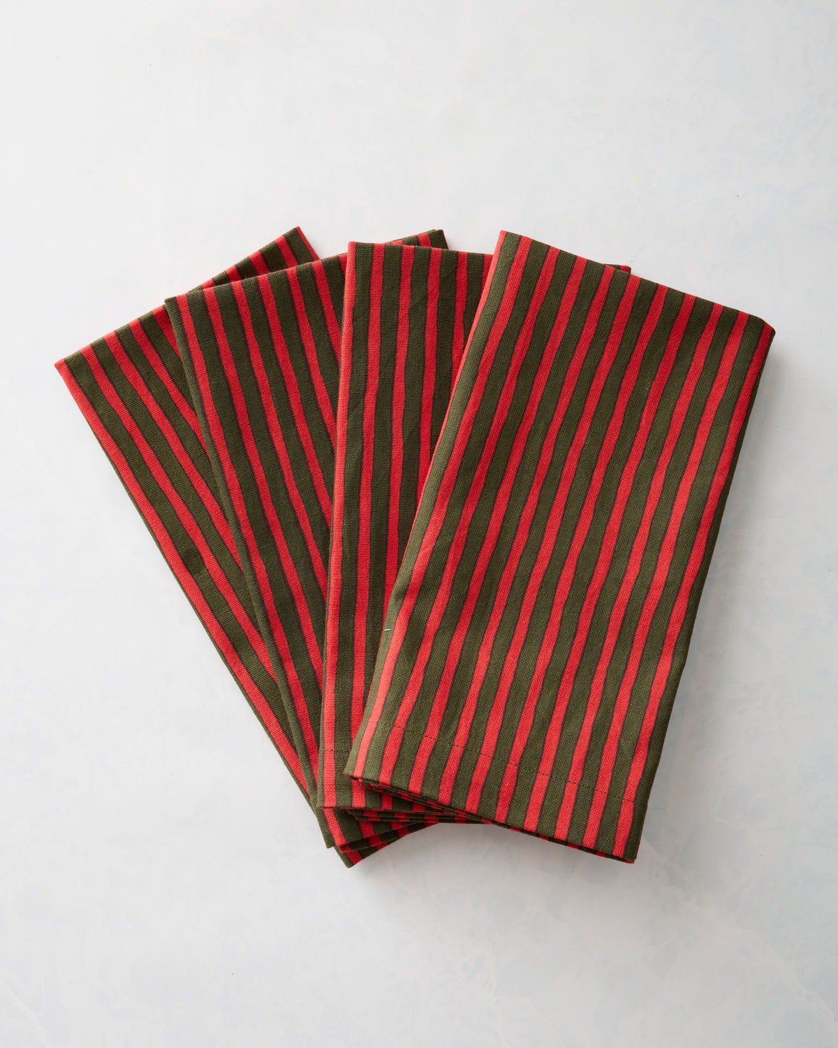 Four red-and-green striped dinner napkins arranged in an overlapping fan.