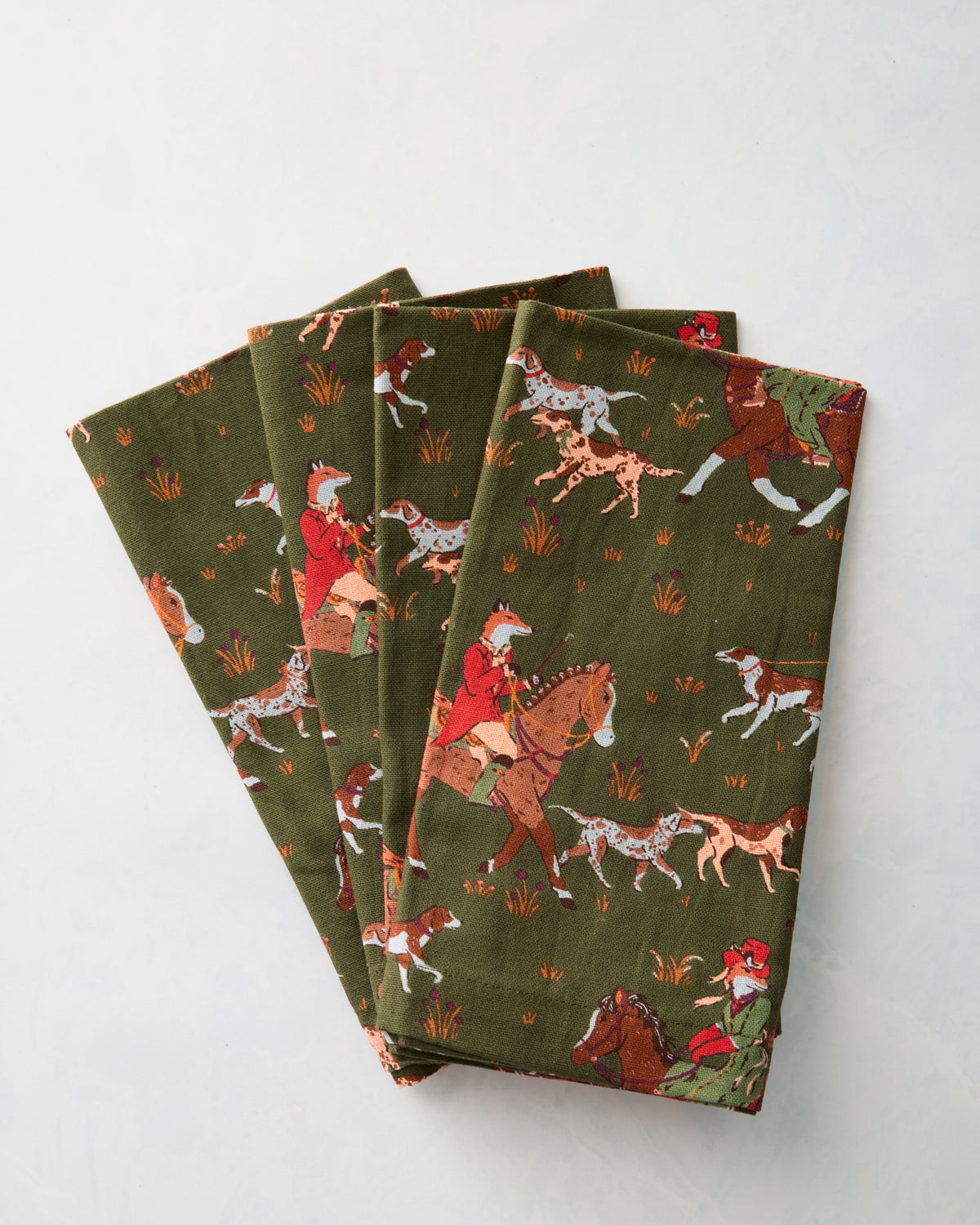Set of four Fox & Hounds dinner napkins folded and fanned out, showing the horse-and-hounds print.