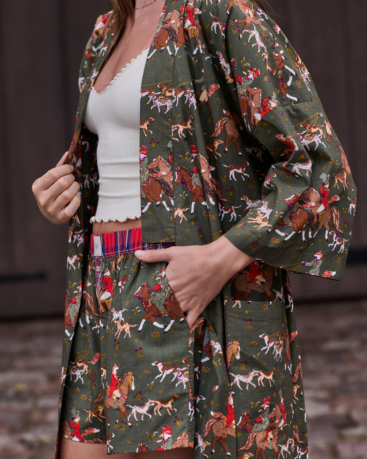 Close-up of the open long robe showing its fox-and-hounds print, front pocket, belt, and layered white top.