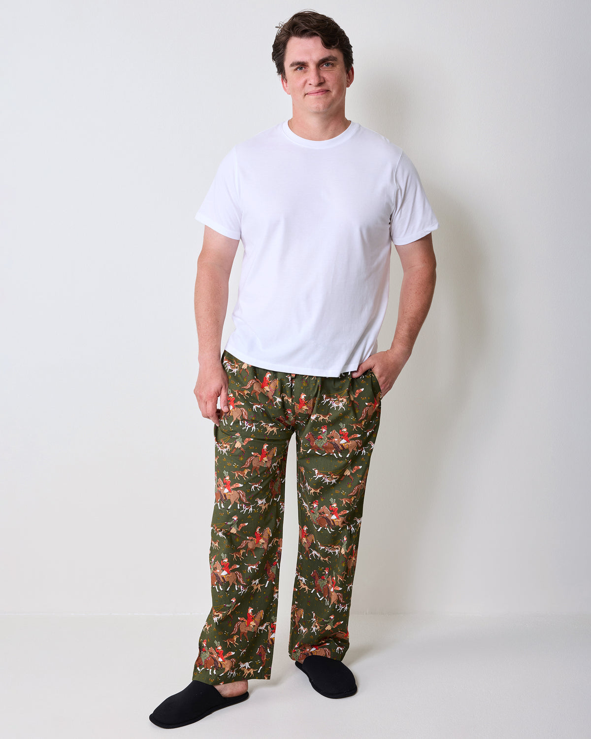 Front three-quarter view of pine green fox-and-rider print long pajama pants, showing the relaxed leg shape and pockets.