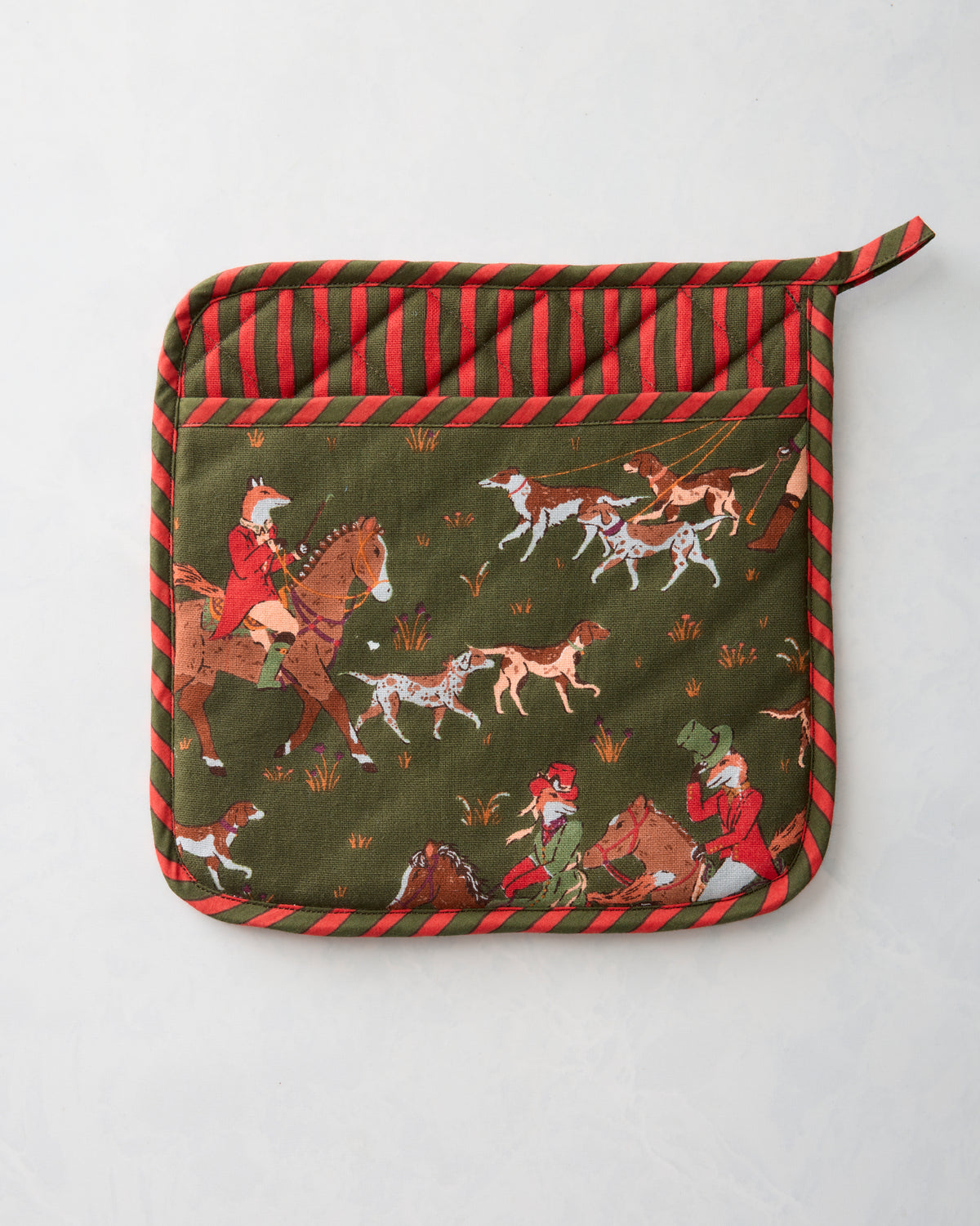 Front of a green and red Fox & Hounds pot holder with a fox-hunting scene showing riders, horses, and dogs.