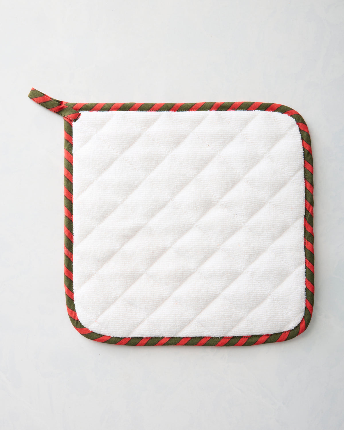 Back of the Fox & Hounds pot holder, showing white diagonal quilting and red-and-green striped edging.