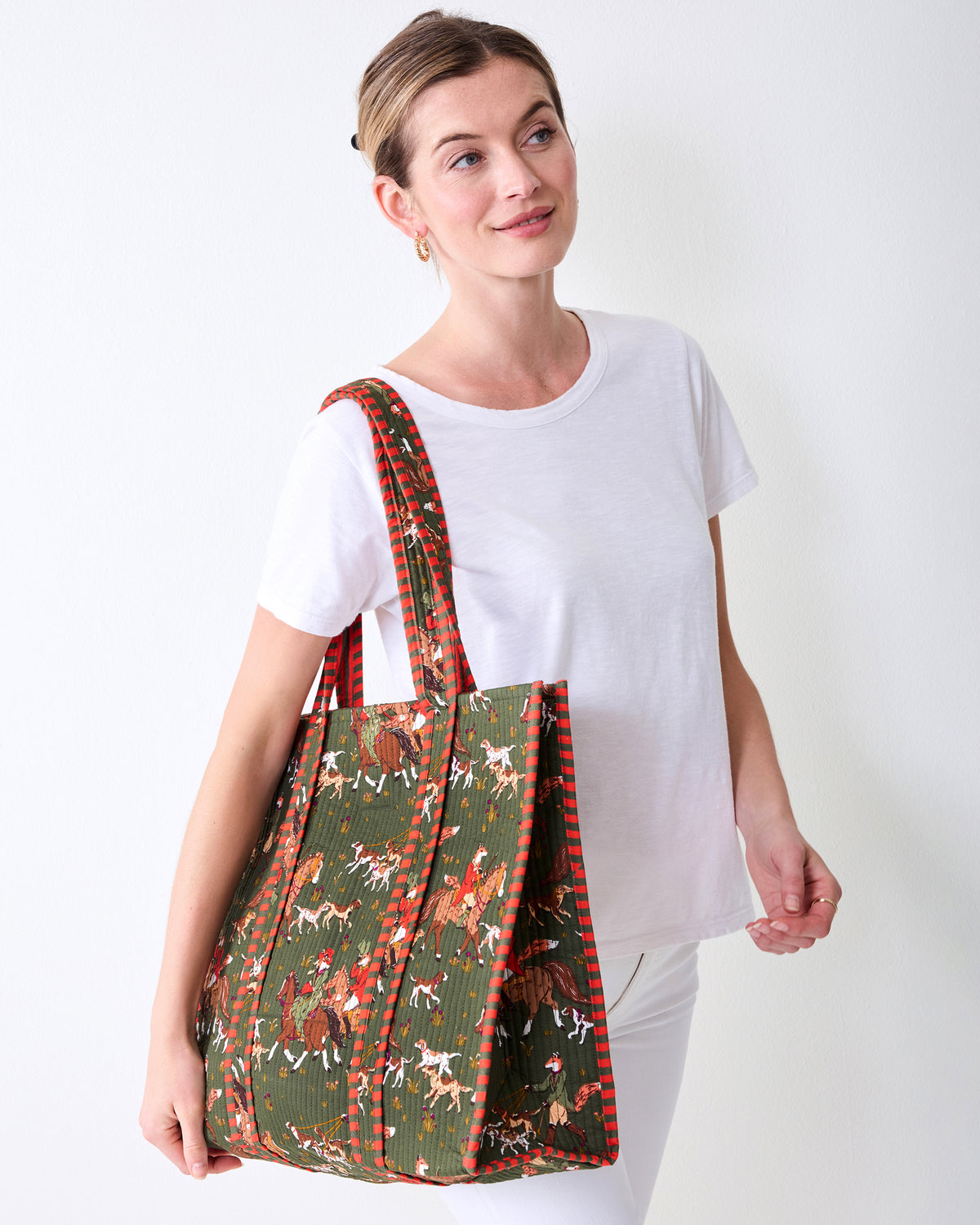 Angled front view of the Pine Grove Traveler Tote showing its fox-and-hounds print and striped trim.