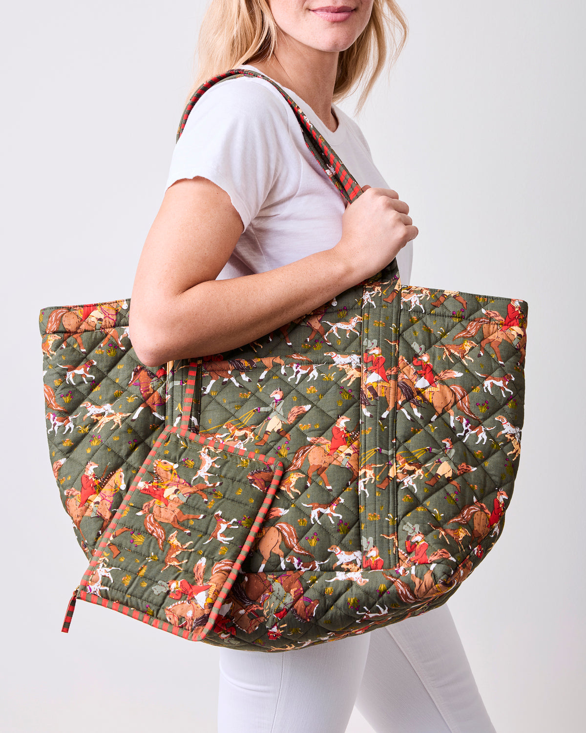 Person carrying the Pine Grove Fox & Hounds weekender bag with its exterior pocket open.