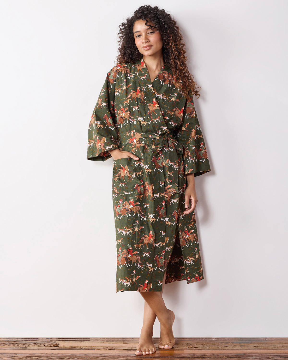 Front view of a person wearing the green fox-and-hounds print long robe with a tied belt and pockets.