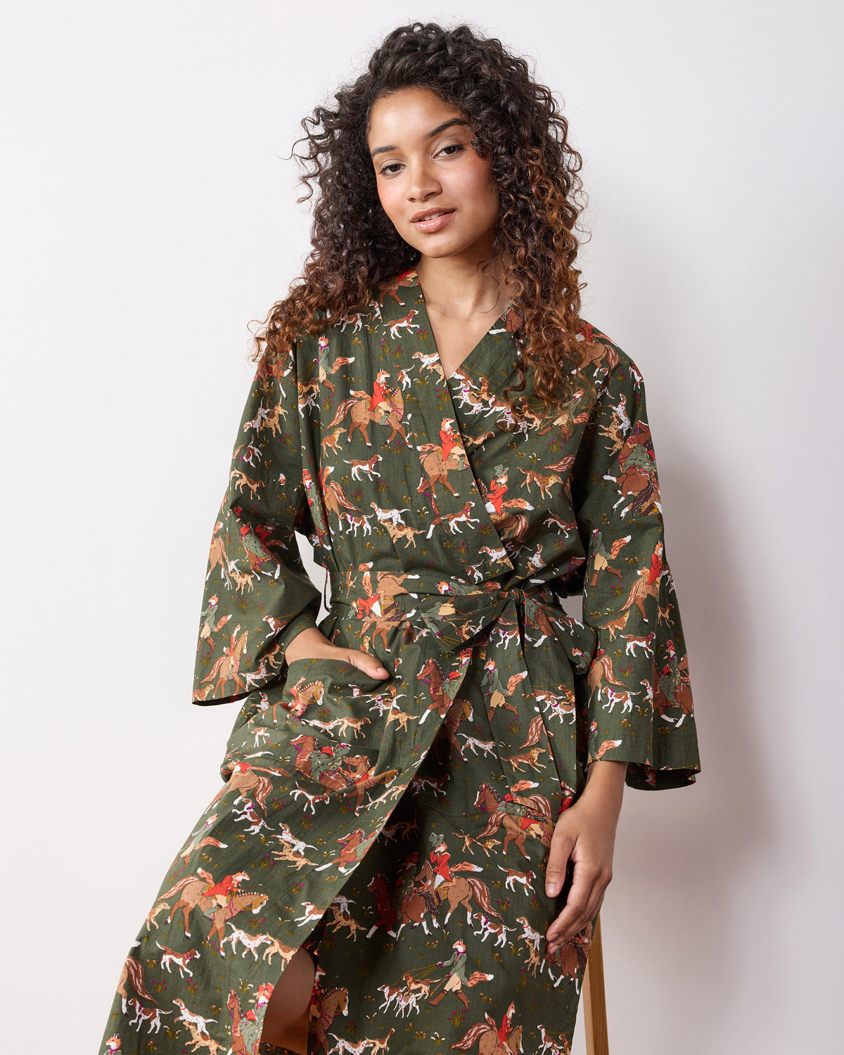 Person wearing a full-length wrap robe with a matching belt and fox-and-hound equestrian print